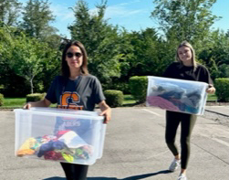  staff carrying boxes of clothing